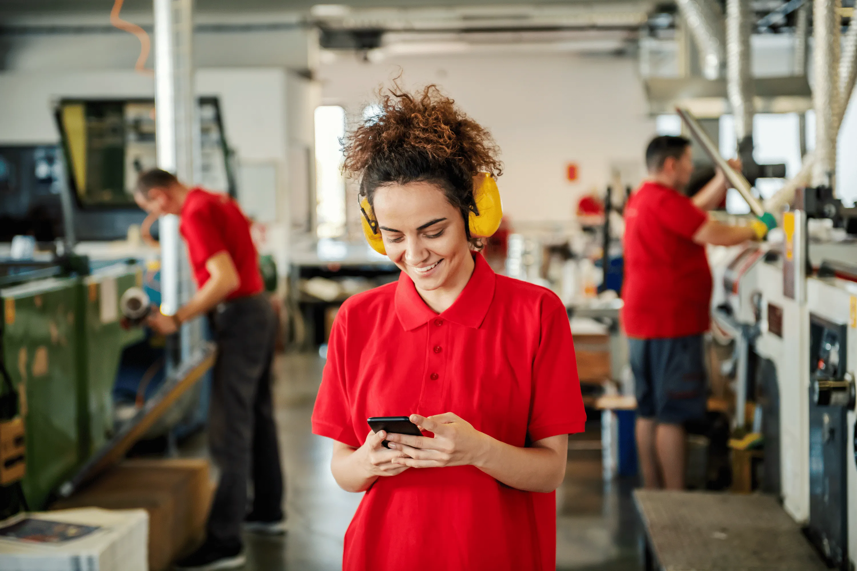 An employee holding a phone in a factory