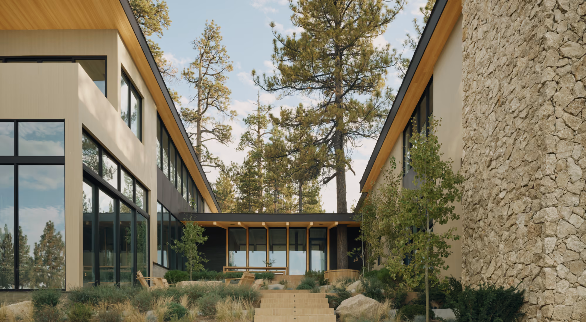 a modern mountain home with a courtyard in the forest on a lake