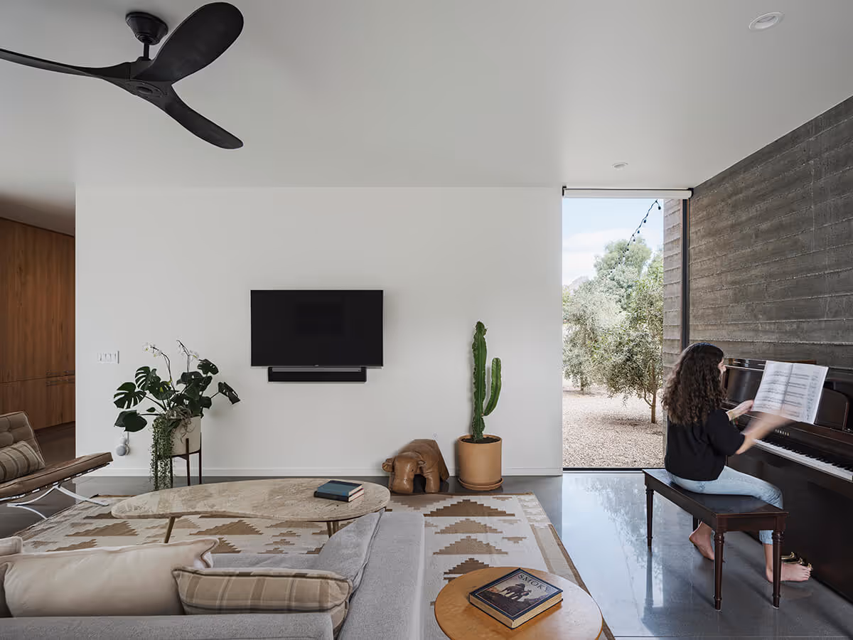 den with piano and boardformed concrete wall at a modern desert house in Phoenix by The Ranch Mine