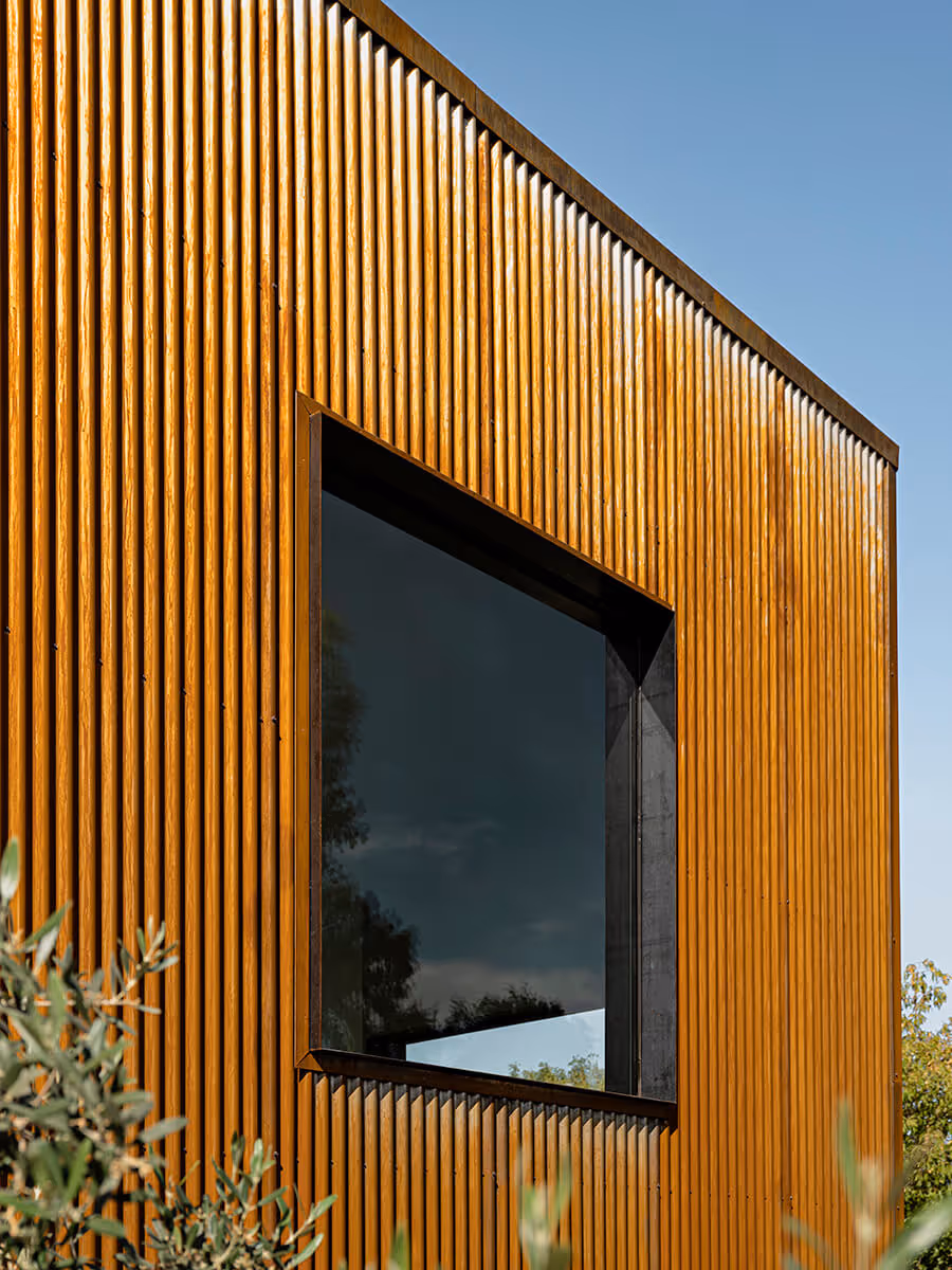 rusted corrugate metal siding with square window at a modern desert house in Phoenix by The Ranch Mine