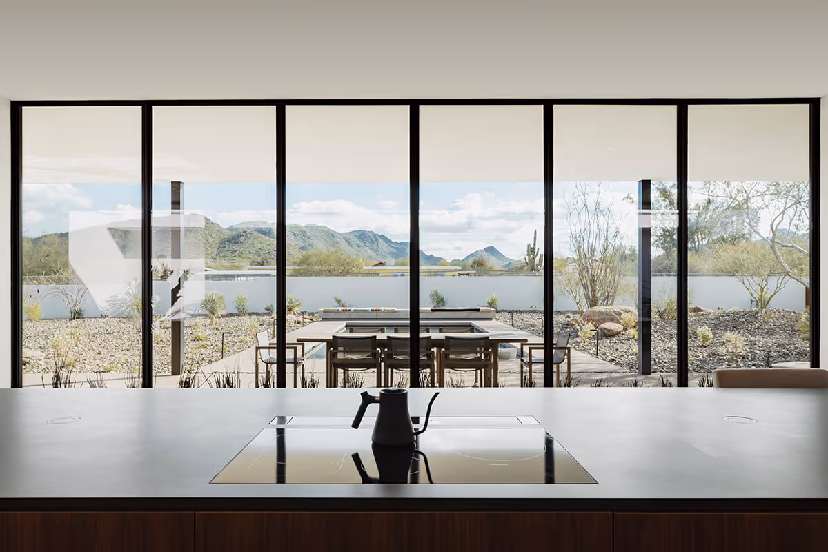kitchen with a view towards a pool in a modern desert house by The Ranch Mine