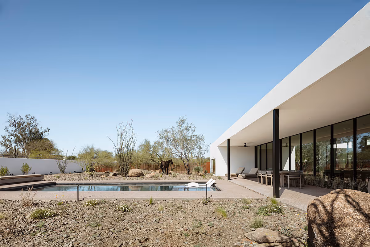 covered patio next to a pool in a modern desert house by The Ranch Mine