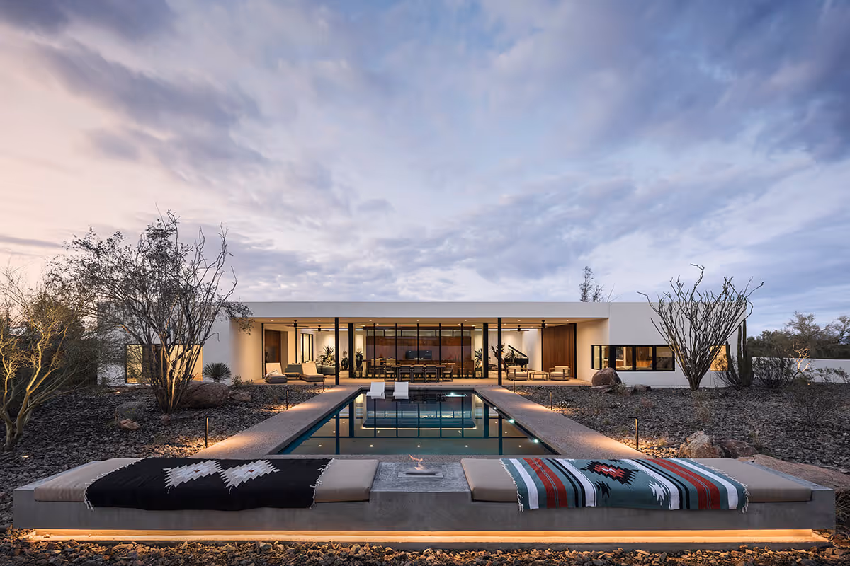 twilight bench with a firepit next to a pool in the desert in a modern desert house by The Ranch Mine