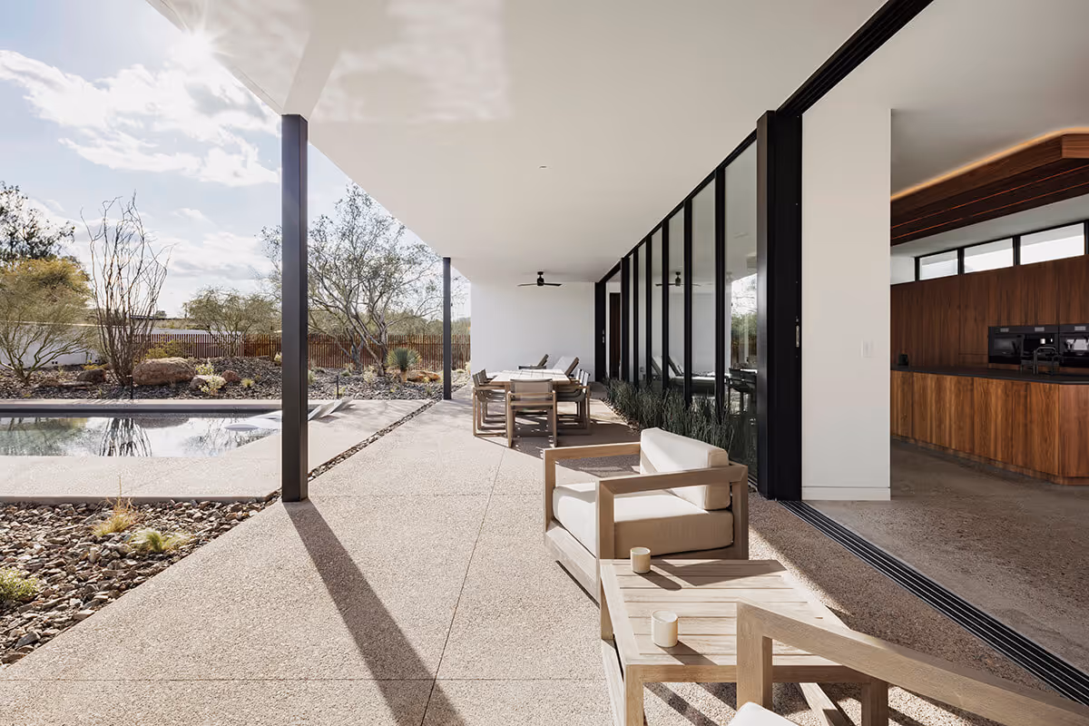 covered patio next to a pool in a modern desert house by The Ranch Mine