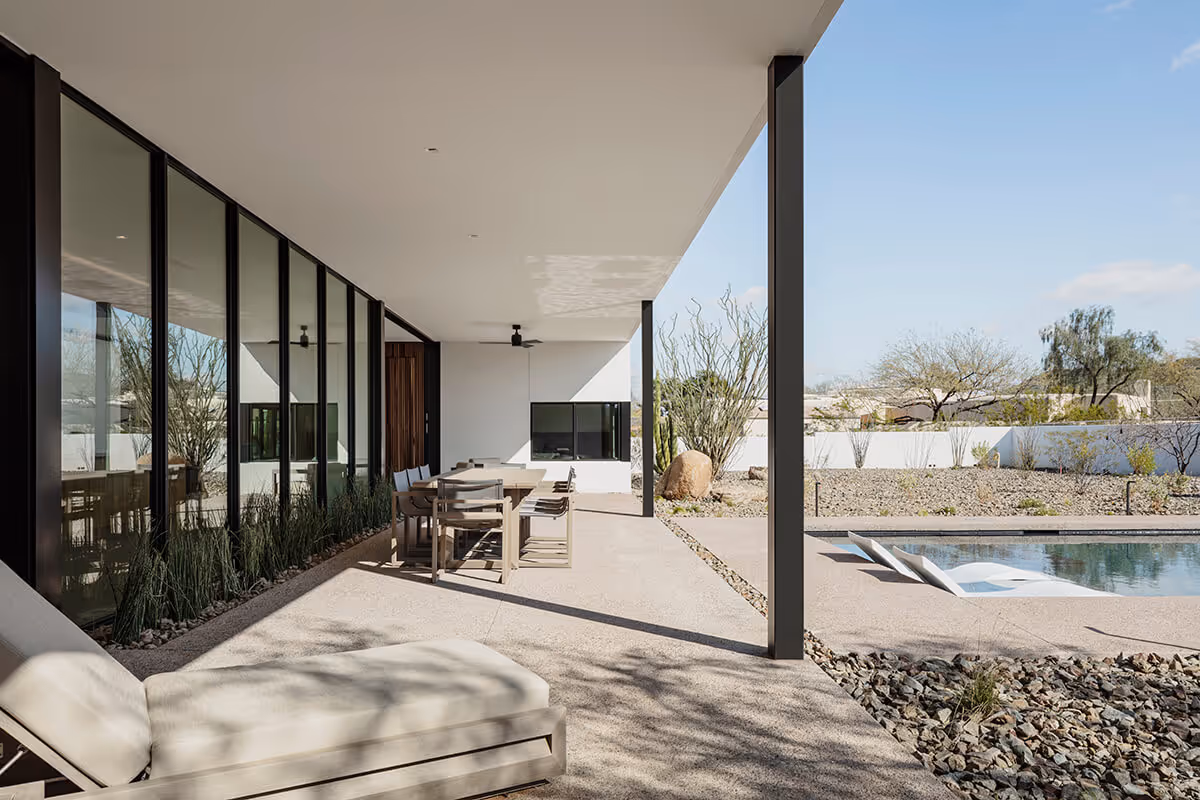 covered patio next to a pool in a modern desert house by The Ranch Mine