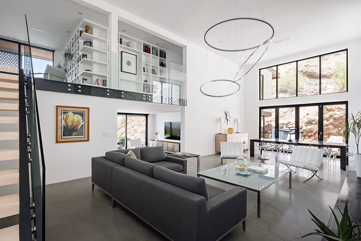 Double height living room with glass stairway and railing at a modern home in Phoenix by The Ranch Mine
