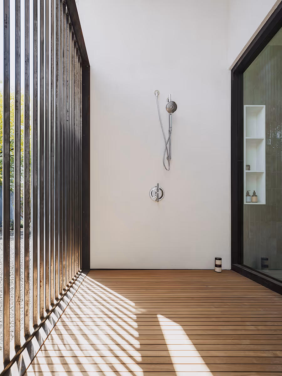 Outdoor shower with filtered light at a modern home in Phoenix by The Ranch Mine