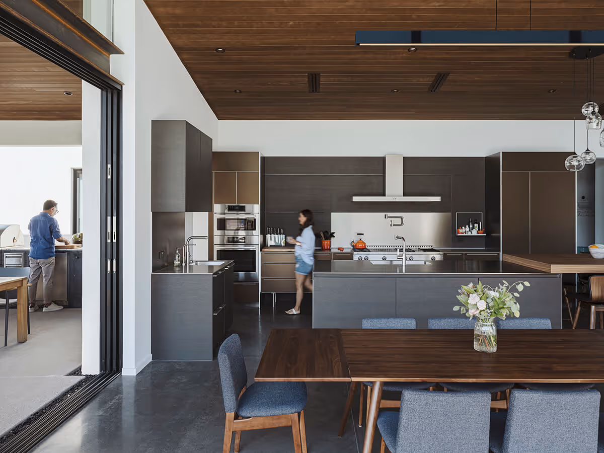 Kitchen and dining with a dark wood ceiling at a modern home in Phoenix by The Ranch Mine