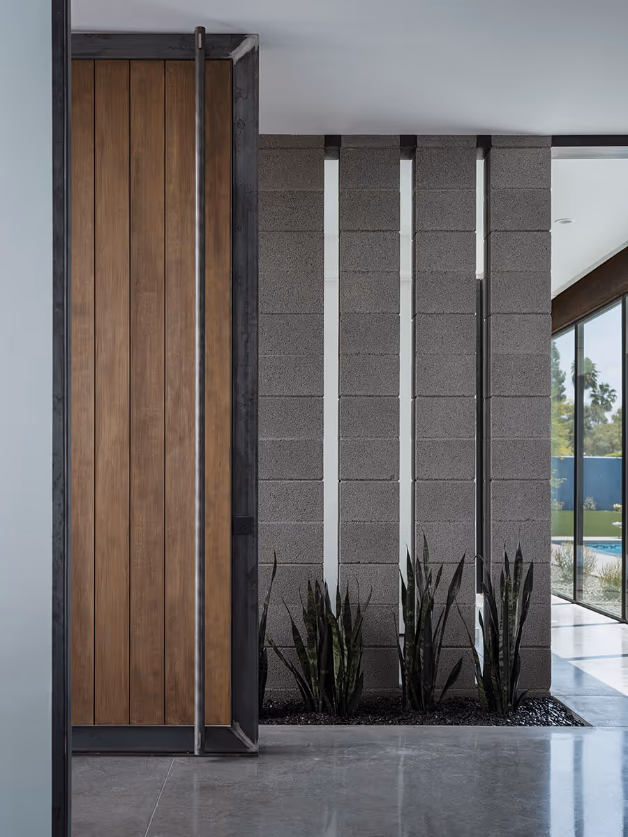 Wood pivot door with concrete block detail at a modern home in Phoenix by The Ranch Mine