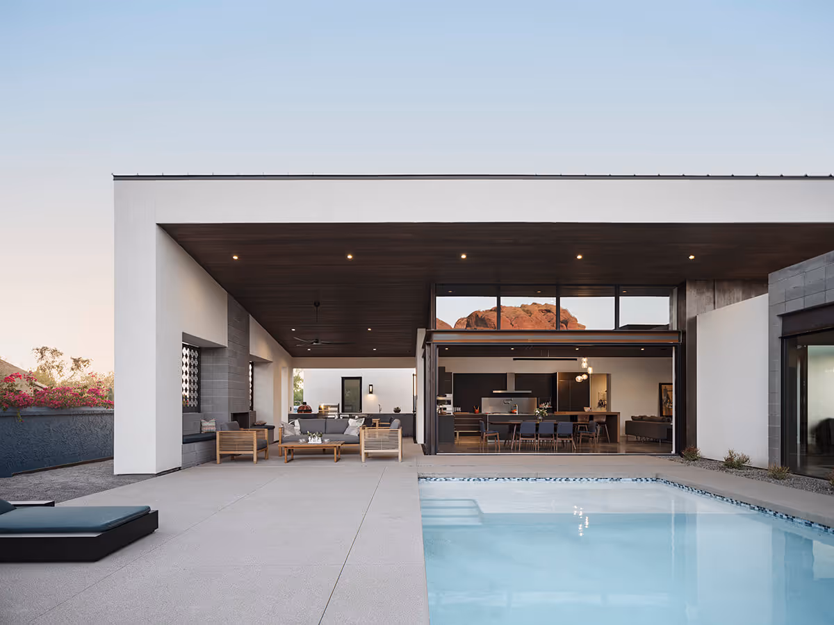 Dusk view of a pool with indoor outdoor living at a modern home in Phoenix by The Ranch Mine