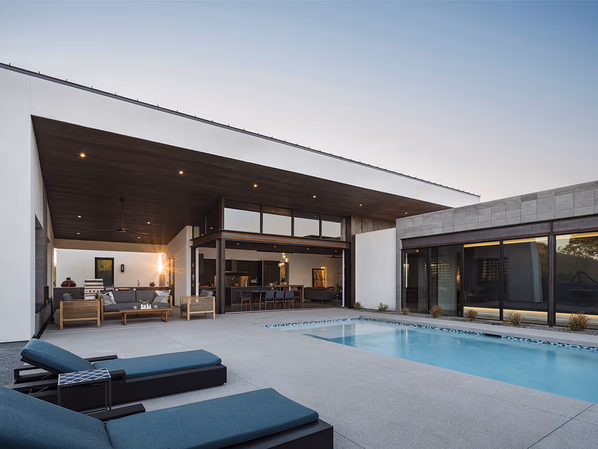 Dusk view of a pool with indoor outdoor living at a modern home in Phoenix by The Ranch Mine