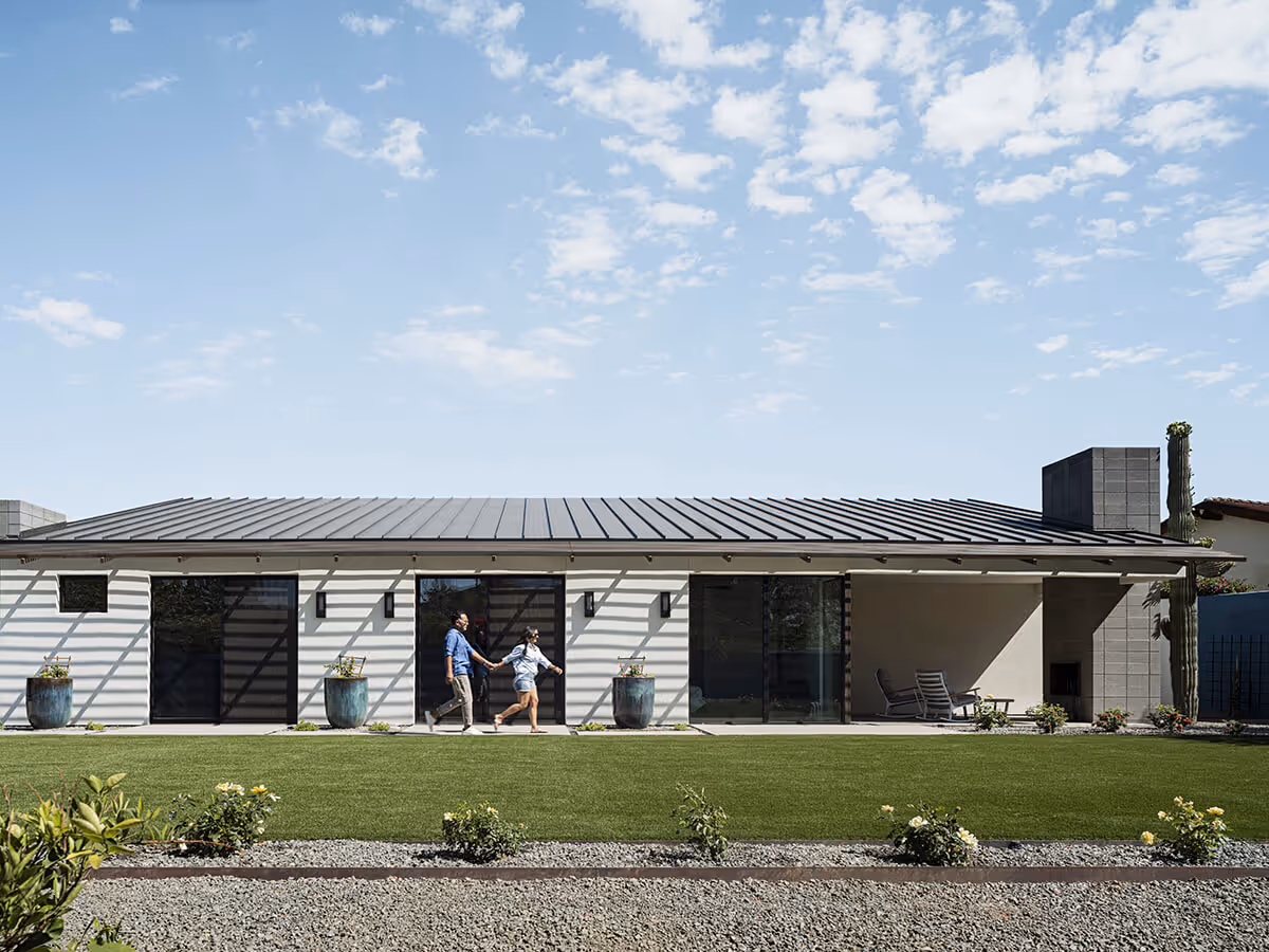 Stucco house with standing seam metal roof and concrete block fireplace in Phoenix by The Ranch Mine