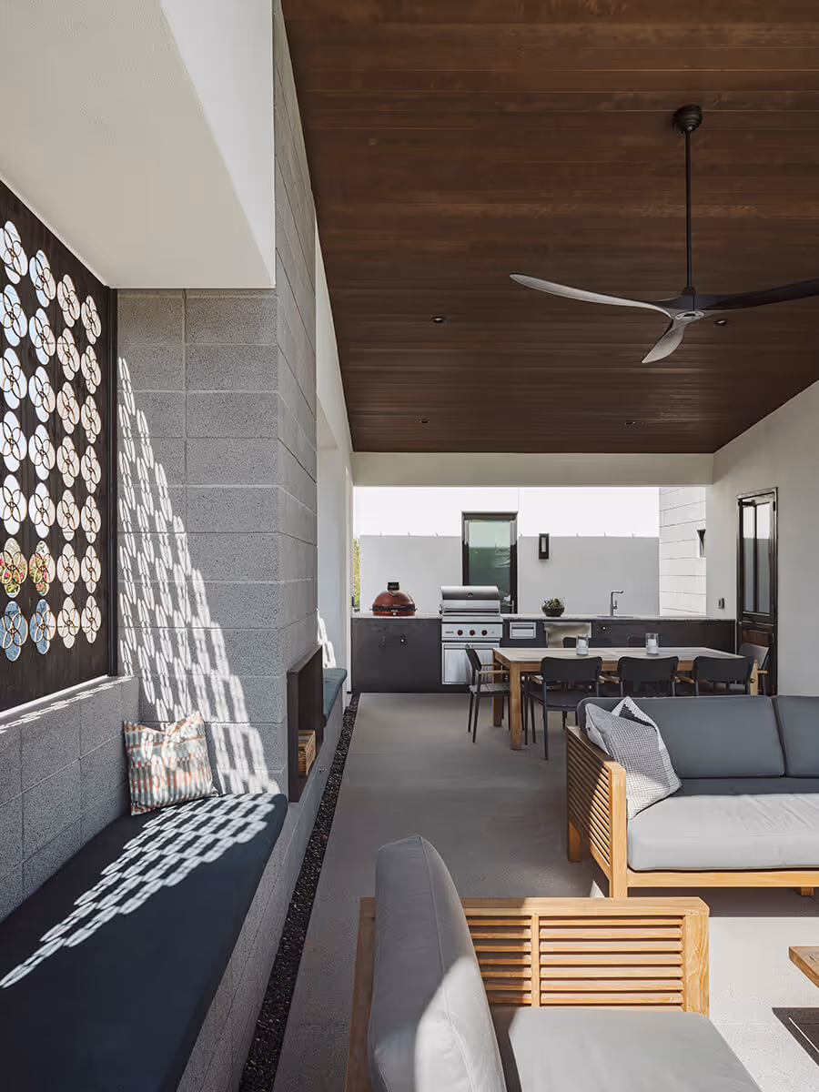 Built in seat with custom steel panel filtering light on a covered patio at a modern home in Phoenix by The Ranch Mine
