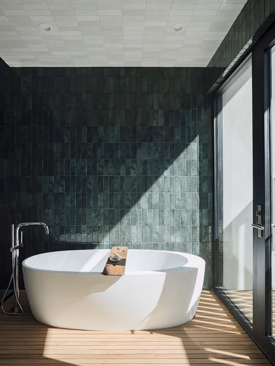 Bathtub with wood flooring and green tile at a modern home in Phoenix by The Ranch Mine