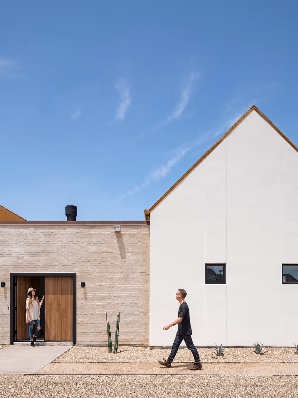 Exterior with white stucco, adobe colored brick and rusted steel at a southwest modern house by The Ranch Mine