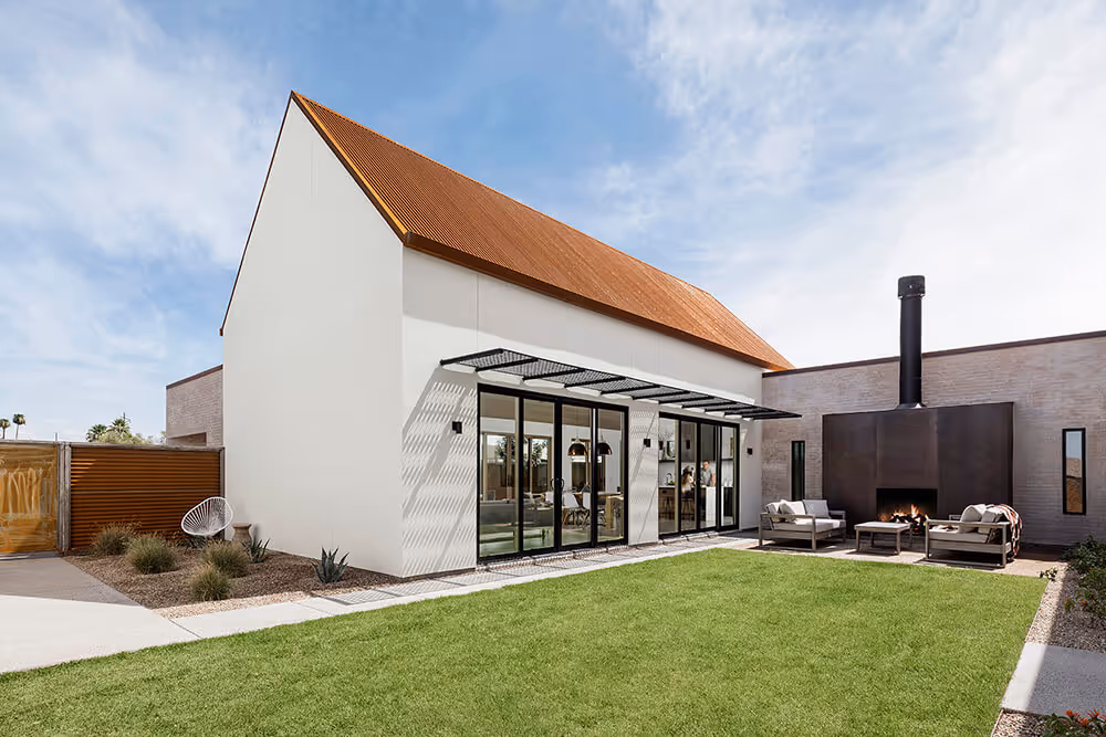 Central courtard with white stucco, adobe colored brick and rusted steel at a southwest modern house by The Ranch Mine