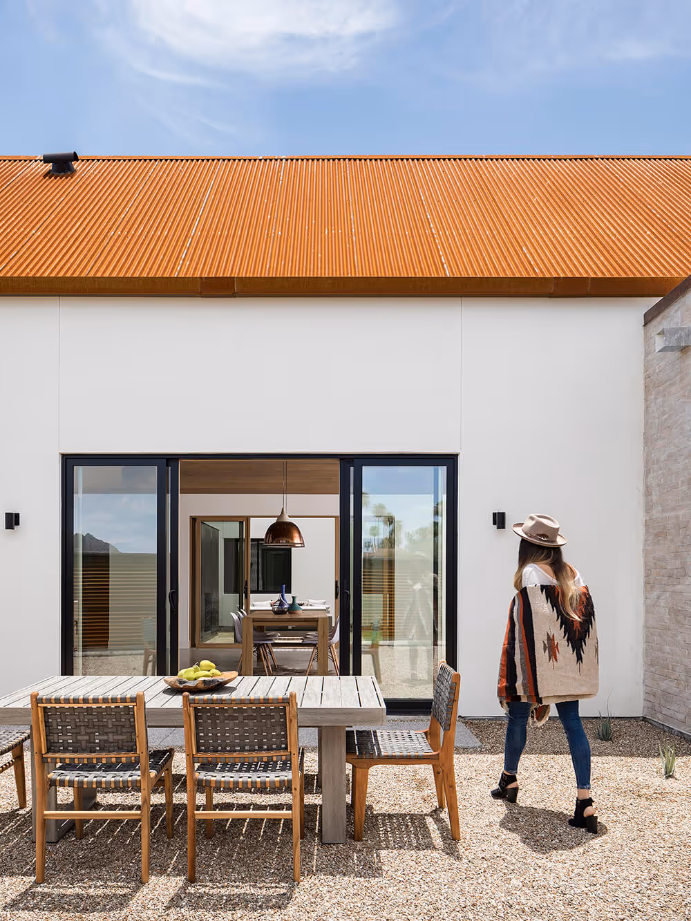 Dining courtyard with white stucco and rusted steel at a southwest modern house by The Ranch Mine
