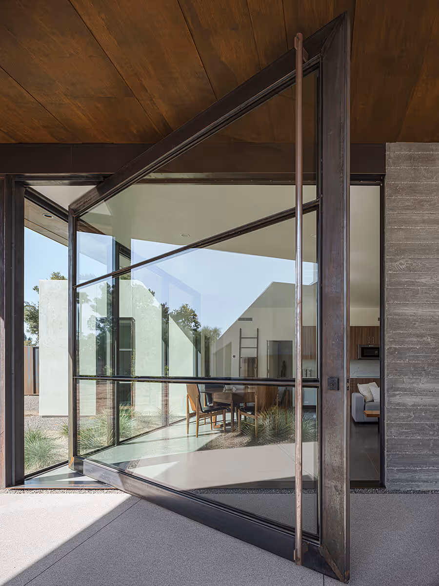 Huge steel and glass pivot door on a casita in Phoenix by The Ranch Mine