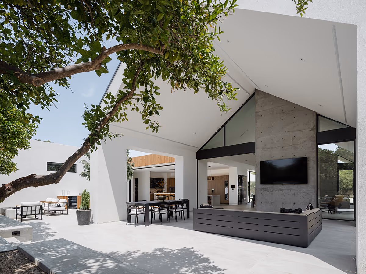 indoor outdoor living with concrete fireplace at modern gable house in Paradise Valley Arizona by The Ranch Mine