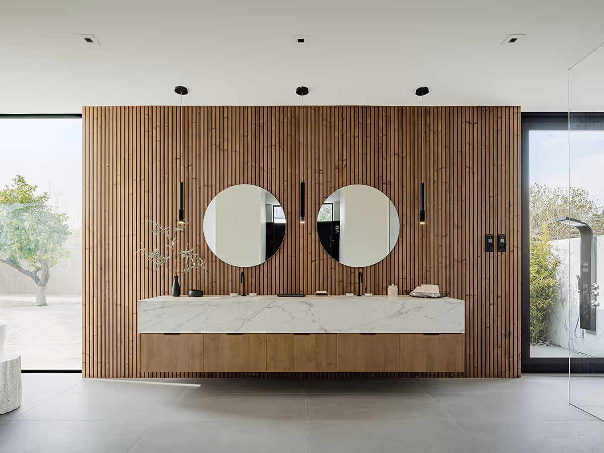 bathroom with circle mirrors, lunawood detail and chunky marble counter at modern gable house in Paradise Valley Arizona by The Ranch Mine