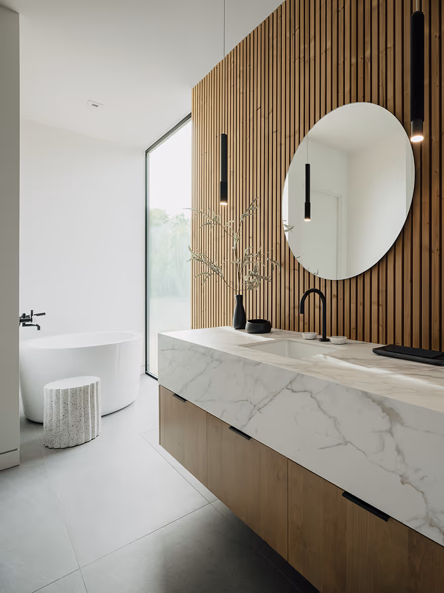 bathroom with circle mirrors, lunawood detail and chunky marble counter at modern gable house in Paradise Valley Arizona by The Ranch Mine