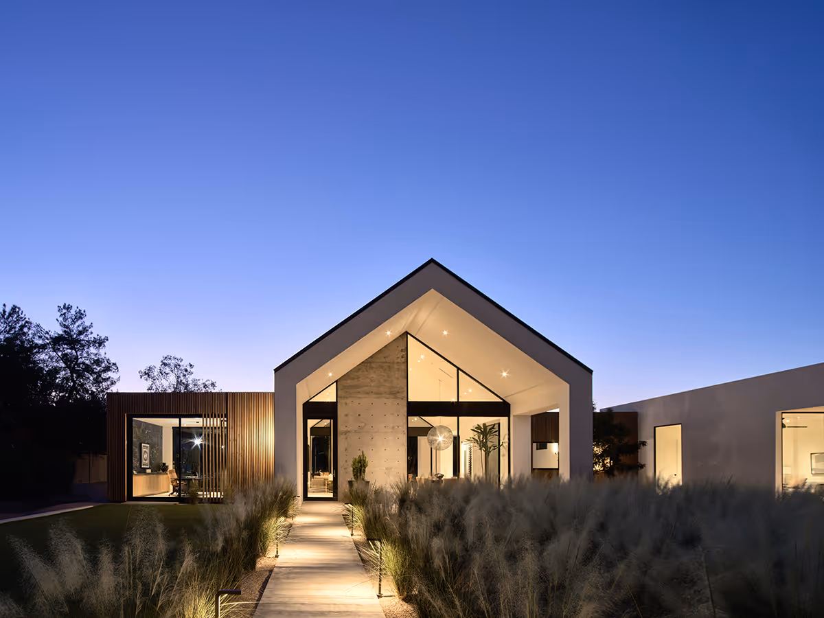 modern stucco and wood gable house at night in Paradise Valley Arizona by The Ranch Mine
