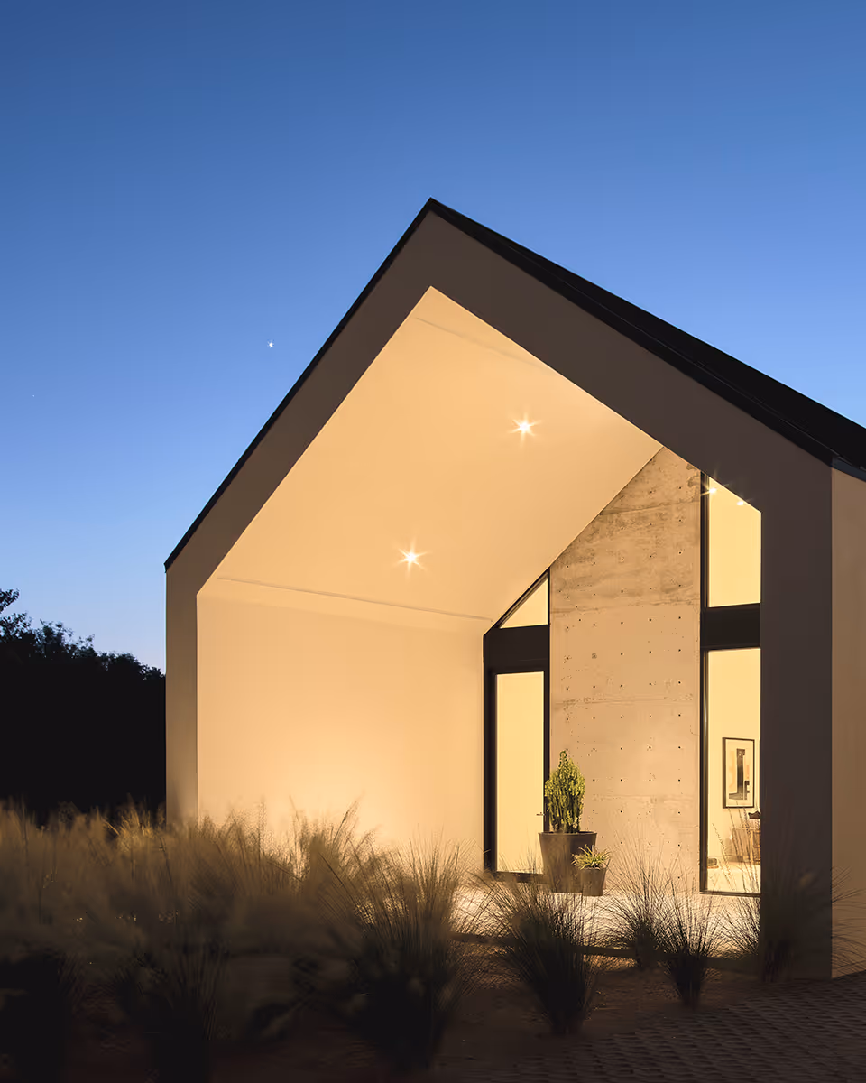 modern stucco and wood gable house at night in Paradise Valley Arizona by The Ranch Mine
