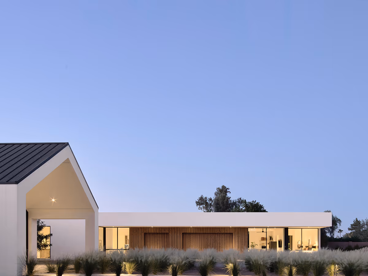 modern stucco and wood gable house at night in Paradise Valley Arizona by The Ranch Mine