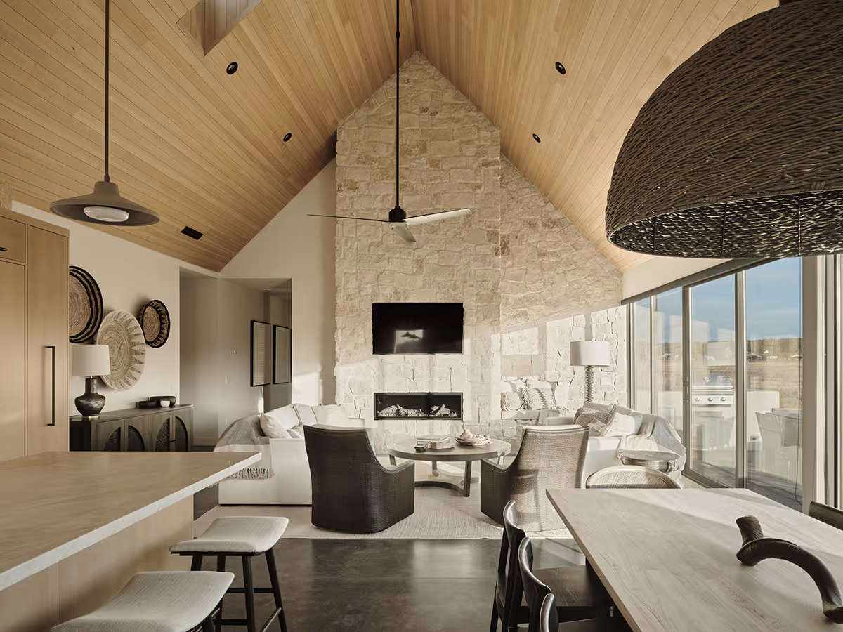 Great room with a stone fireplace and vaulted wood ceiling at a modern Scandinavian house in Flagstaff, Arizona by The Ranch Mine