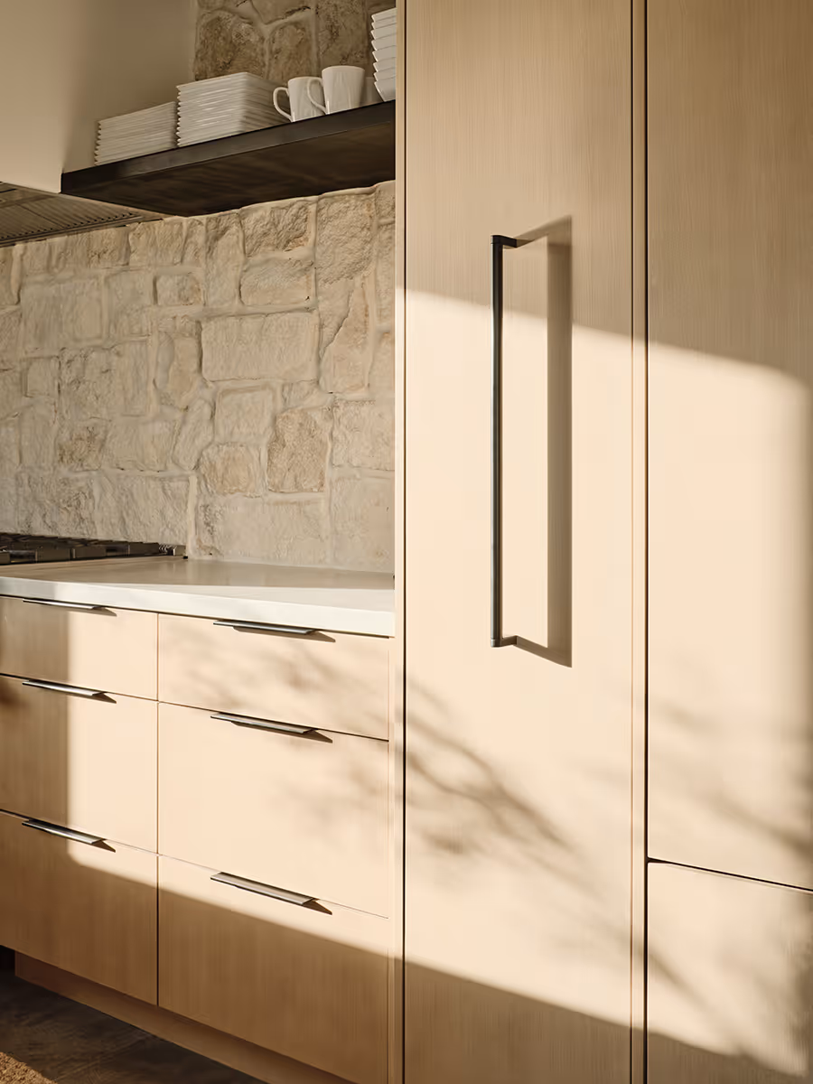 Light and bright kitchen with wood cabinets and a stone backsplash at a modern Scandinavian house in Flagstaff, Arizona by The Ranch Mine