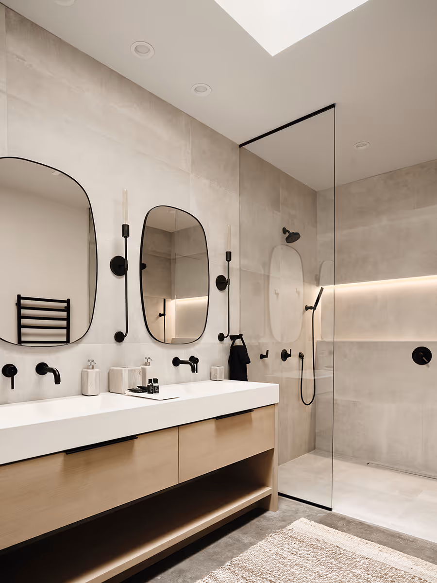Skylit bathroom with an LED light in the shower at a modern Scandinavian black exterior house with gabled roofs in Flagstaff, Arizona by The Ranch Mine
