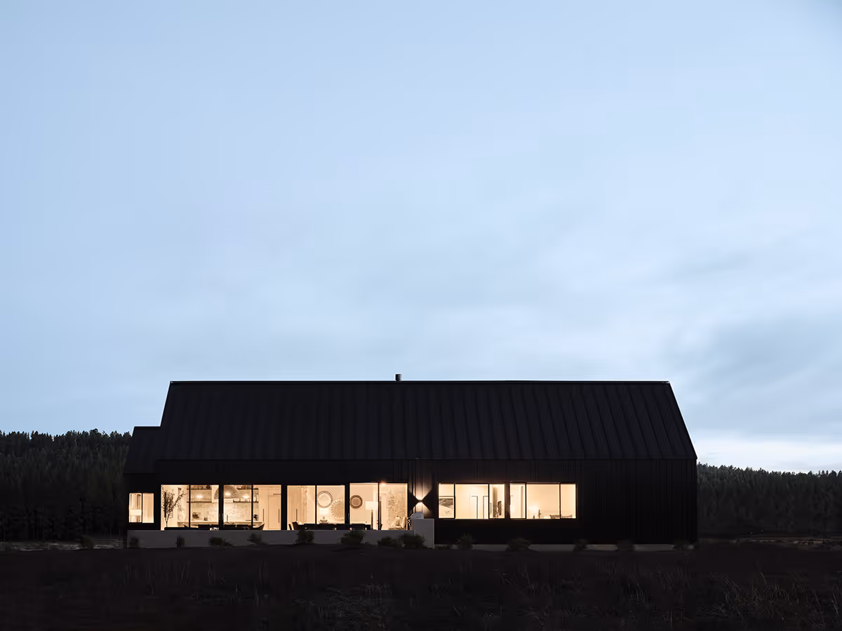 Modern Scandinavian black exterior house with gabled roofs in Flagstaff, Arizona by The Ranch Mine at night