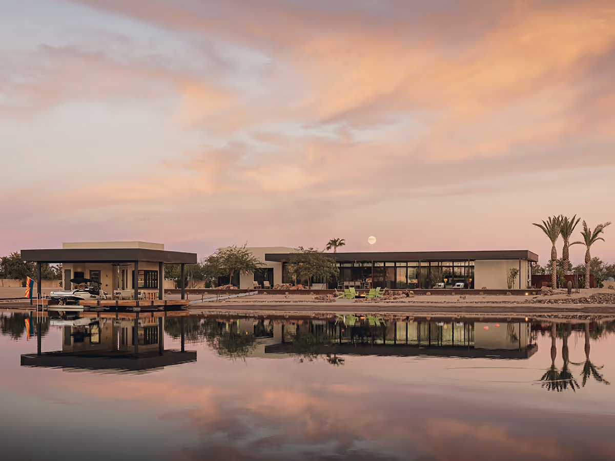 view across lake to a desert modern house in Arizona by The Ranch Mine