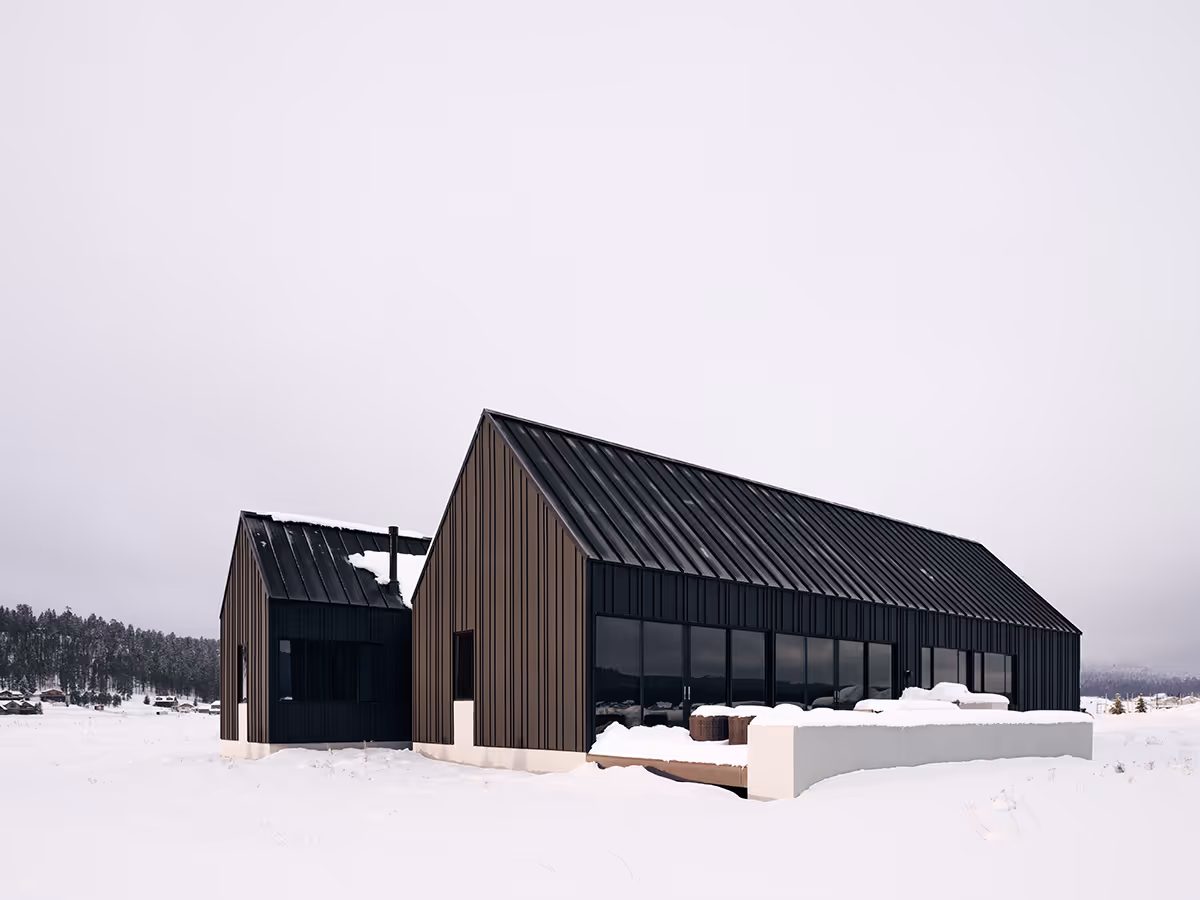 Modern Scandinavian black exterior house with gabled roofs in Flagstaff, Arizona by The Ranch Mine in the snow