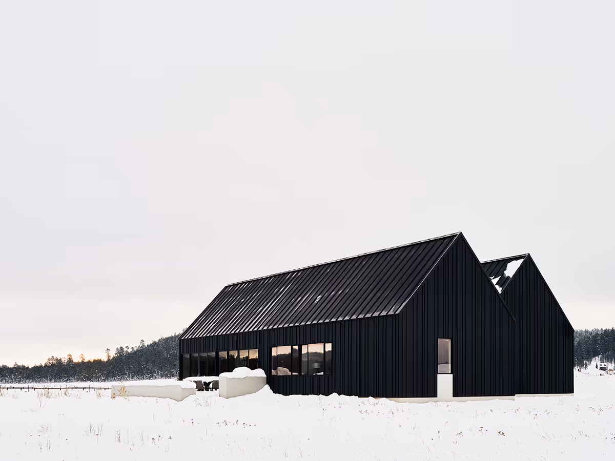Modern Scandinavian black exterior house with gabled roofs in Flagstaff, Arizona by The Ranch Mine in the snow