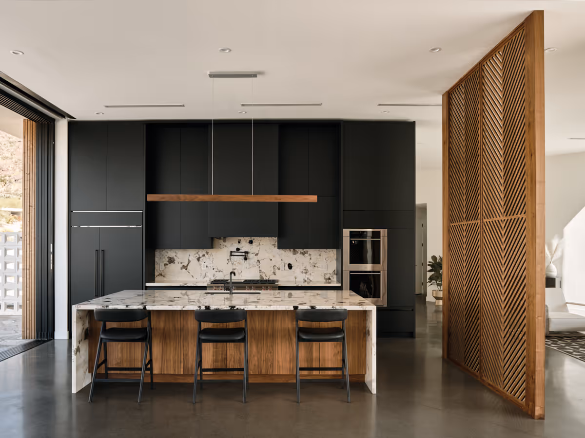 matte black kitchen cabinetry with white marble countertop and wood divider screen by The Ranch Mine