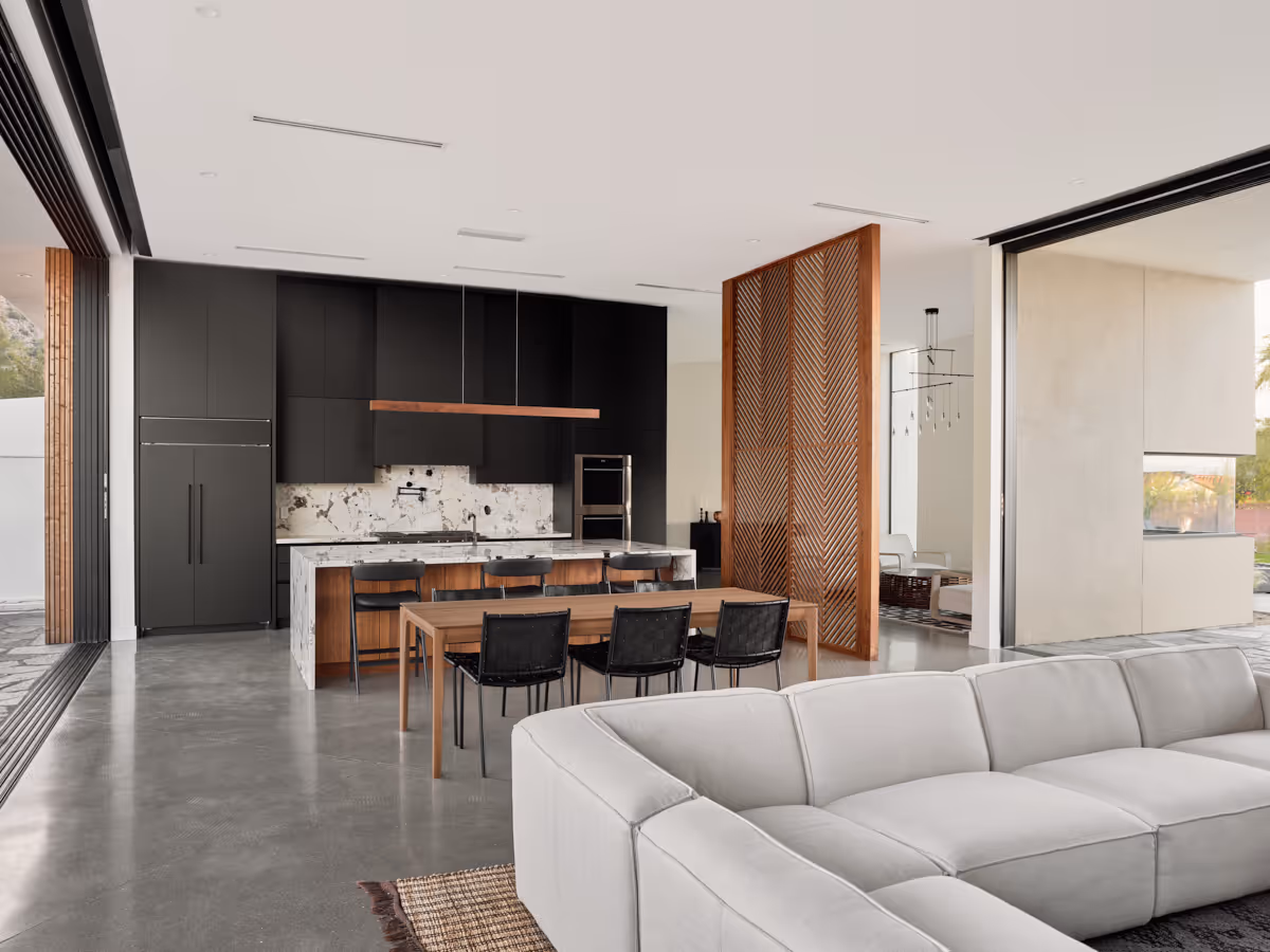 matte black kitchen cabinetry with white marble countertop and wood divider screen by The Ranch Mine