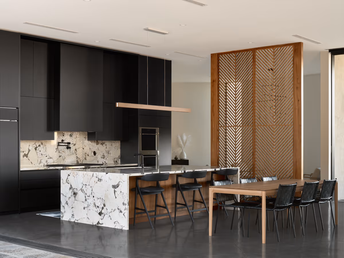matte black kitchen cabinetry with white marble countertop and wood divider screen by The Ranch Mine