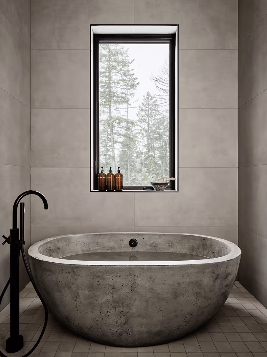 Gray stone bathtub looking at a pine forest in Whitefish, Montana