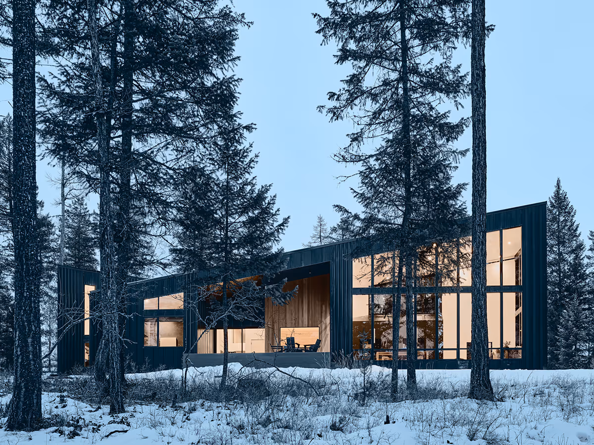 black modern mountain house in a pine forest in Whitefish, Montana