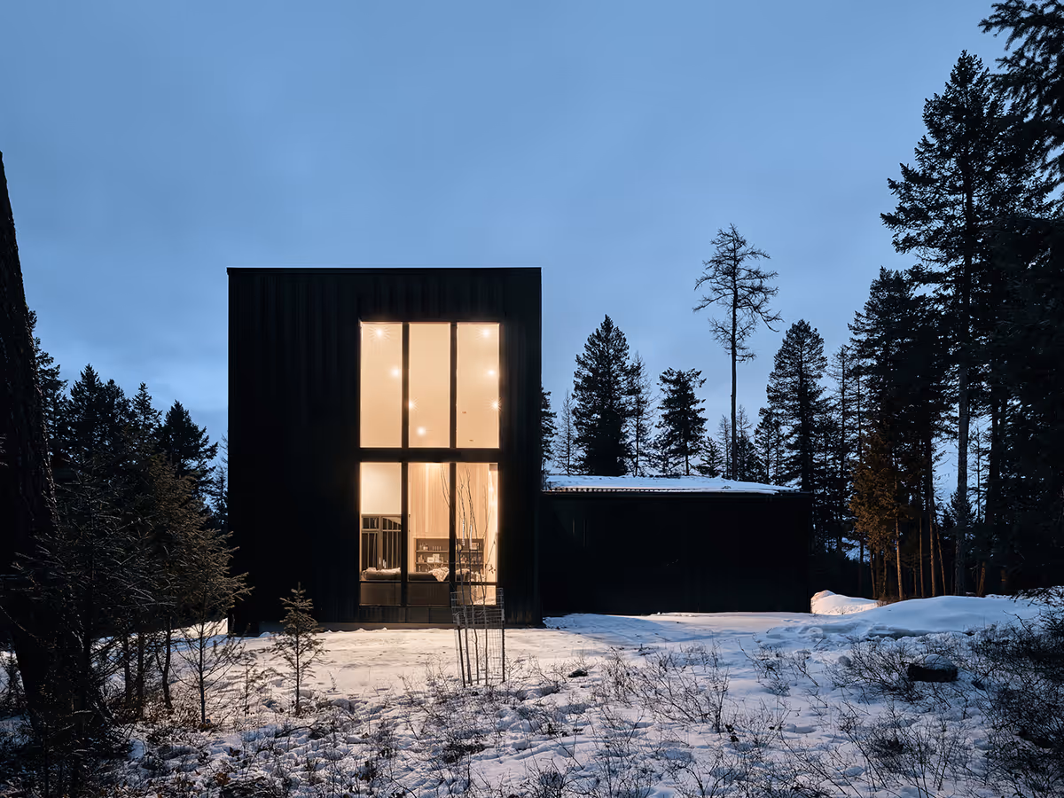 black modern mountain house at night in Whitefish, Montana