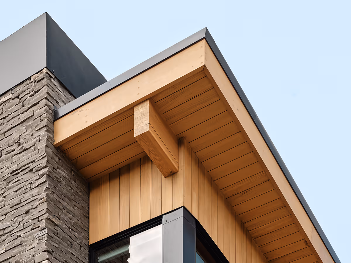 modern mountain home in Durango, Colorado with lots of glass, a stacked stone chimney and wood siding by The Ranch Mine