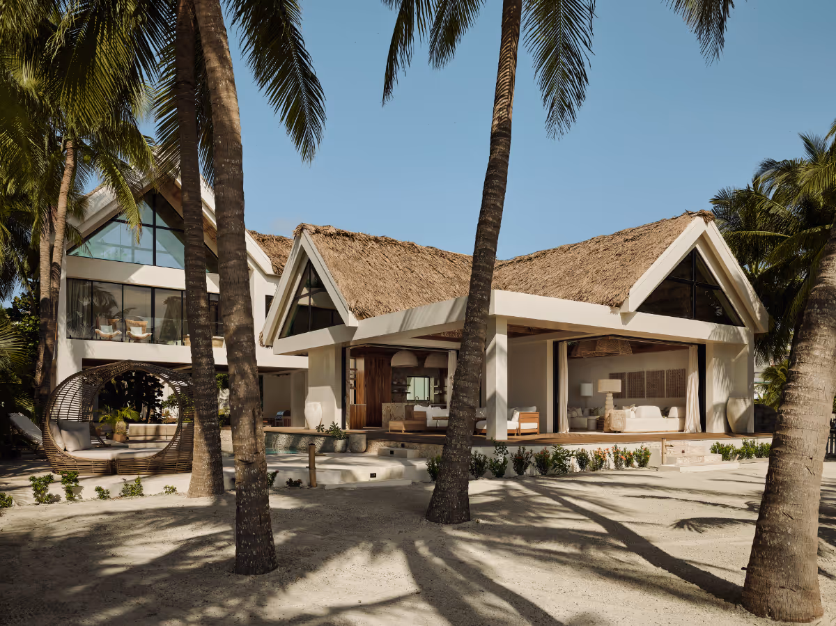 Concrete tropical modern house with a thatched roof and pool in Belize by The Ranch Mine