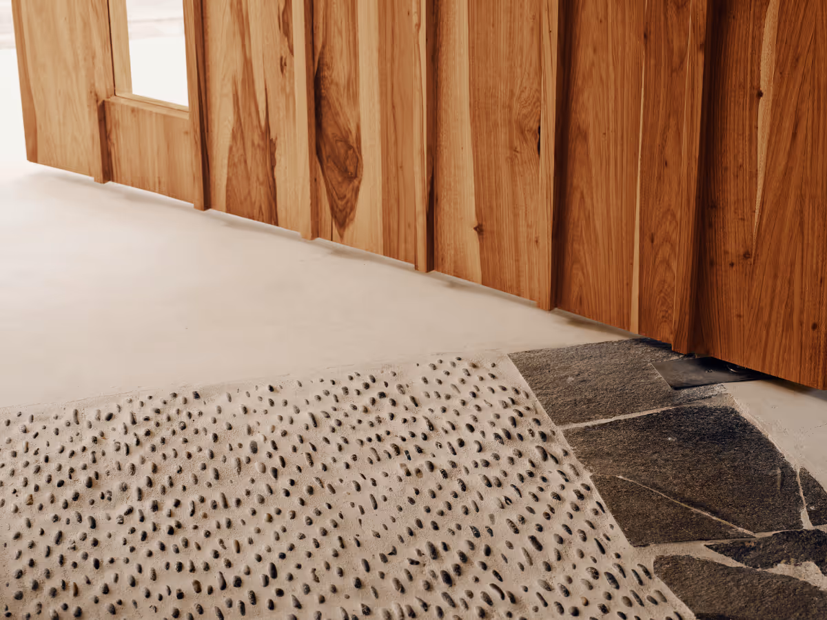 Custom sam wood door with pebble floor detail at a tropical modern house in Belize by The Ranch Mine