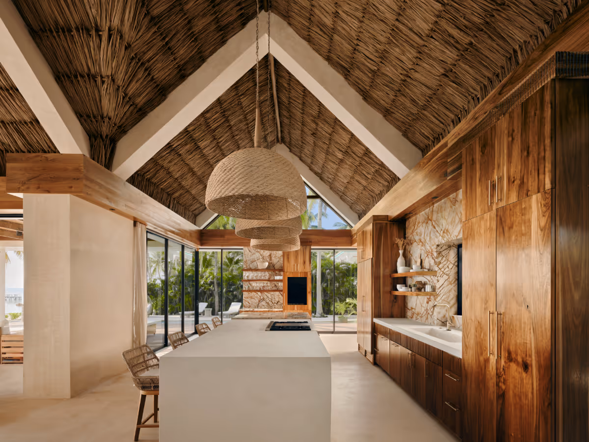 Kitchen with thatched ceiling and chukum walls at a tropical modern house in Belize by The Ranch Mine