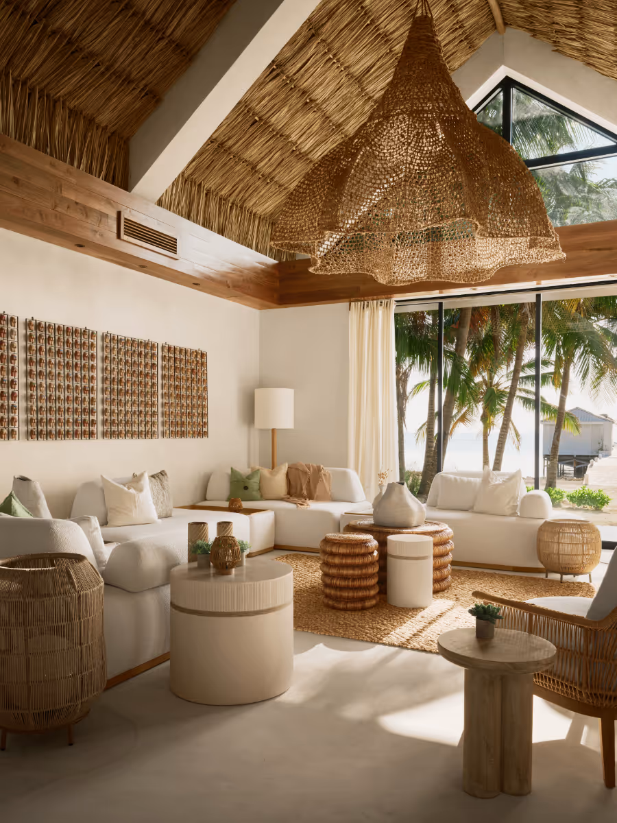 Living room with thatched ceiling and chukum walls at a tropical modern house in Belize by The Ranch Mine