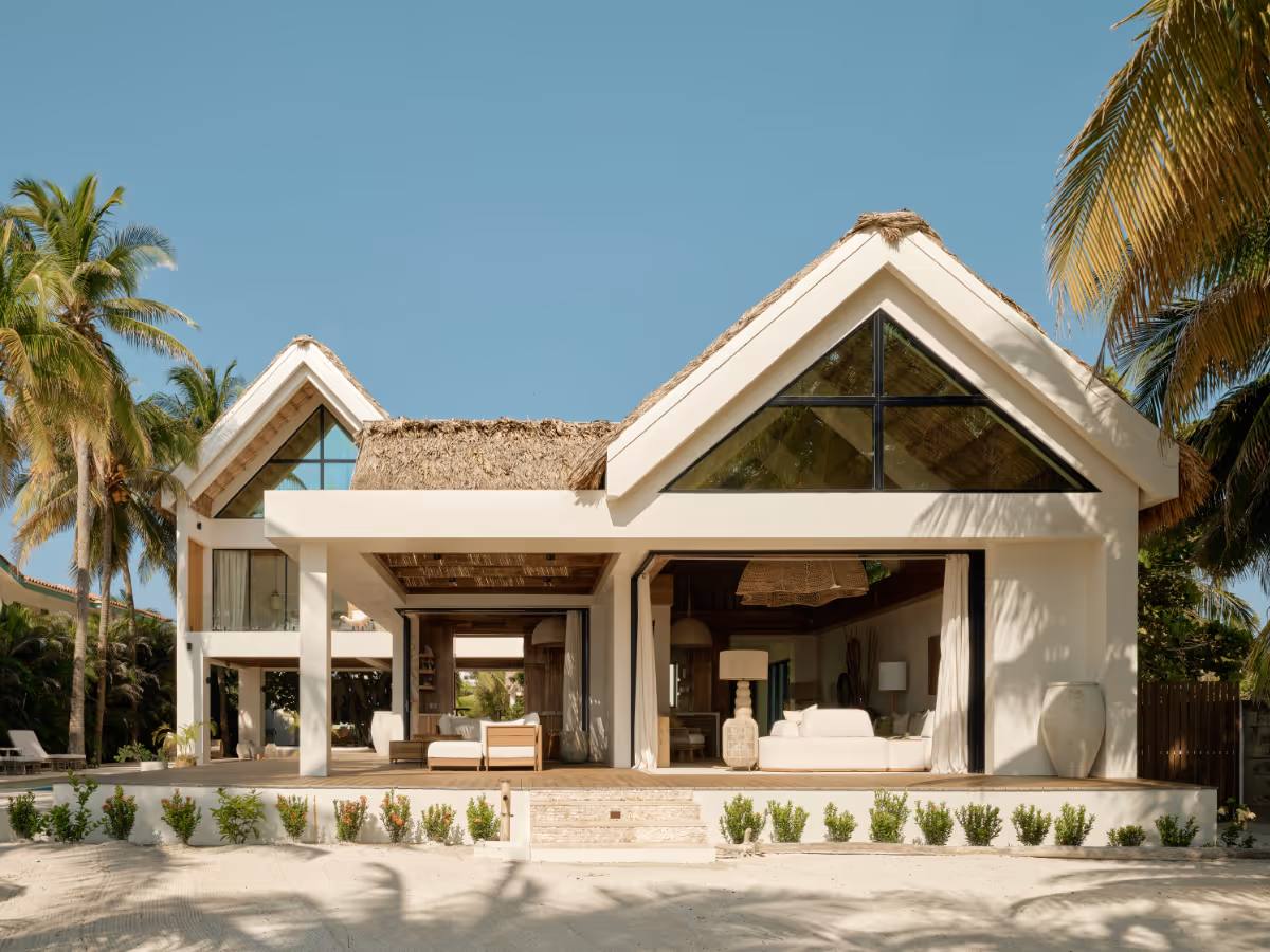 Concrete tropical modern house with a thatched roof and pool in Belize by The Ranch Mine