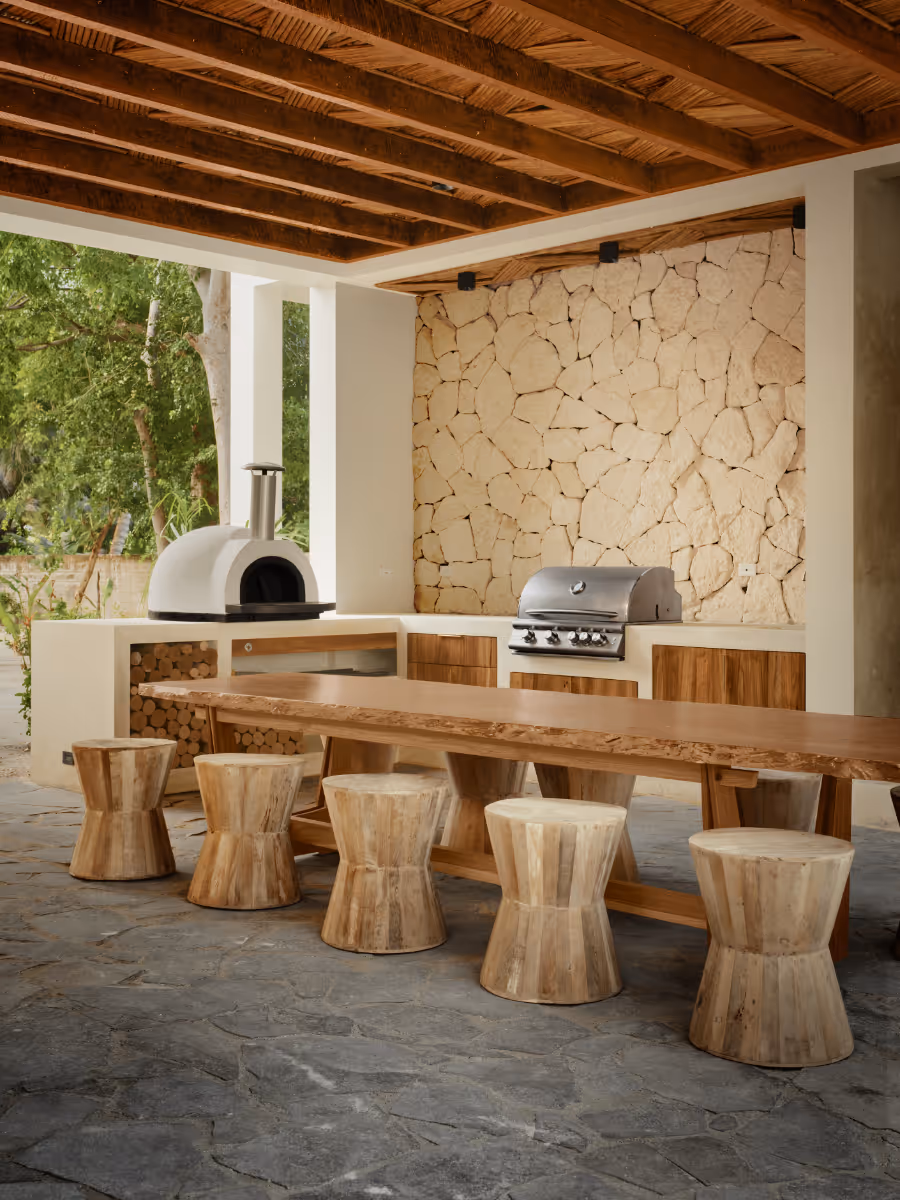 Outdoor kitchen and dining at a tropical modern house in Belize by The Ranch Mine