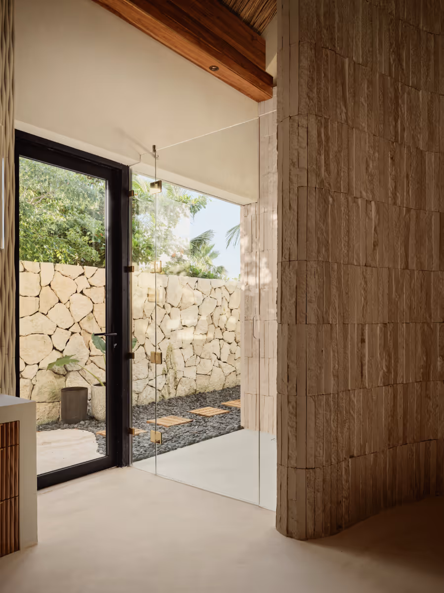 Indoor outdoor shower at a tropical modern house in Belize by The Ranch Mine