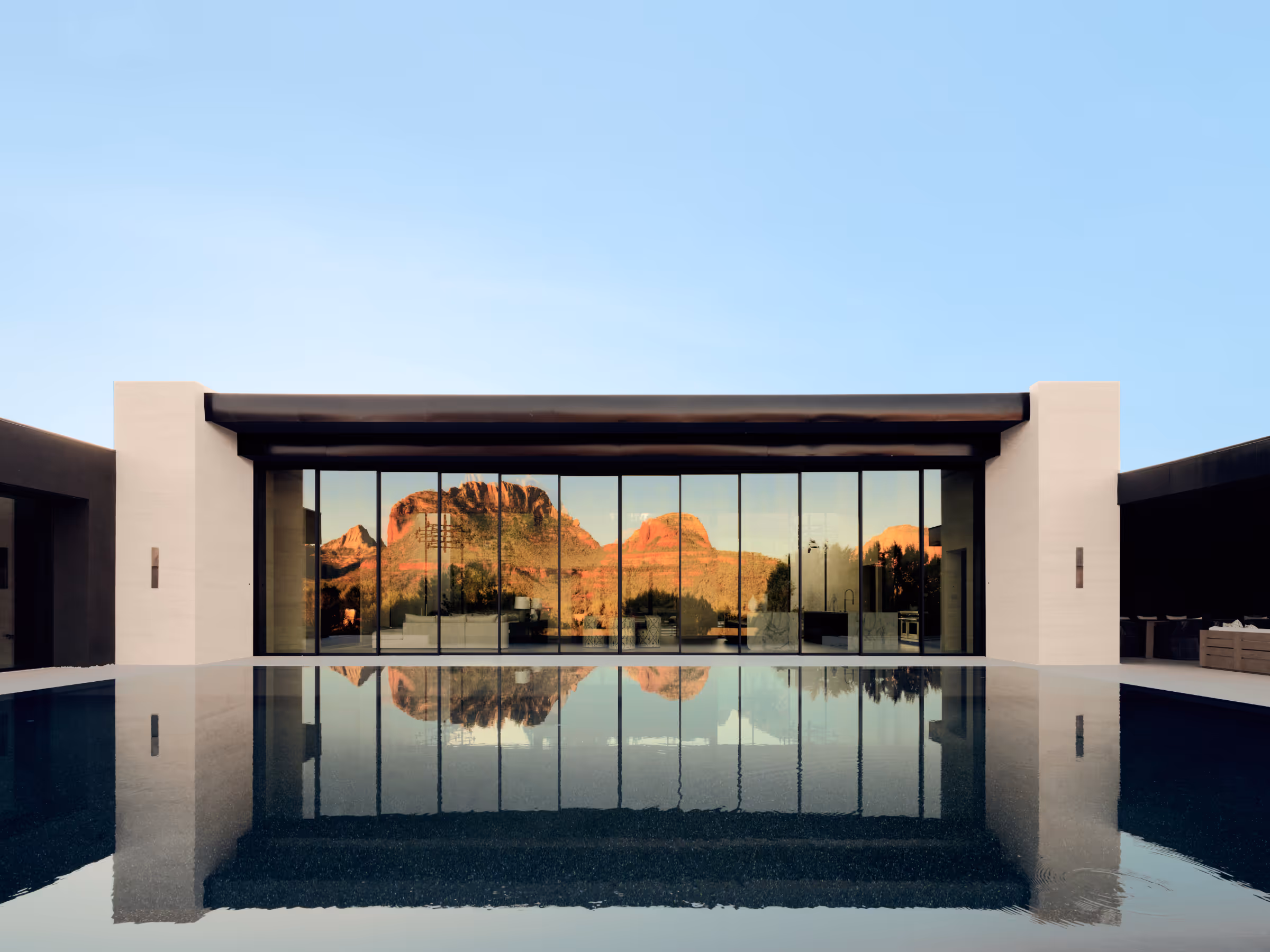 Great room reflecting red-rock views across the courtyard in Seven Canyons, in Sedona by The Ranch Mine.